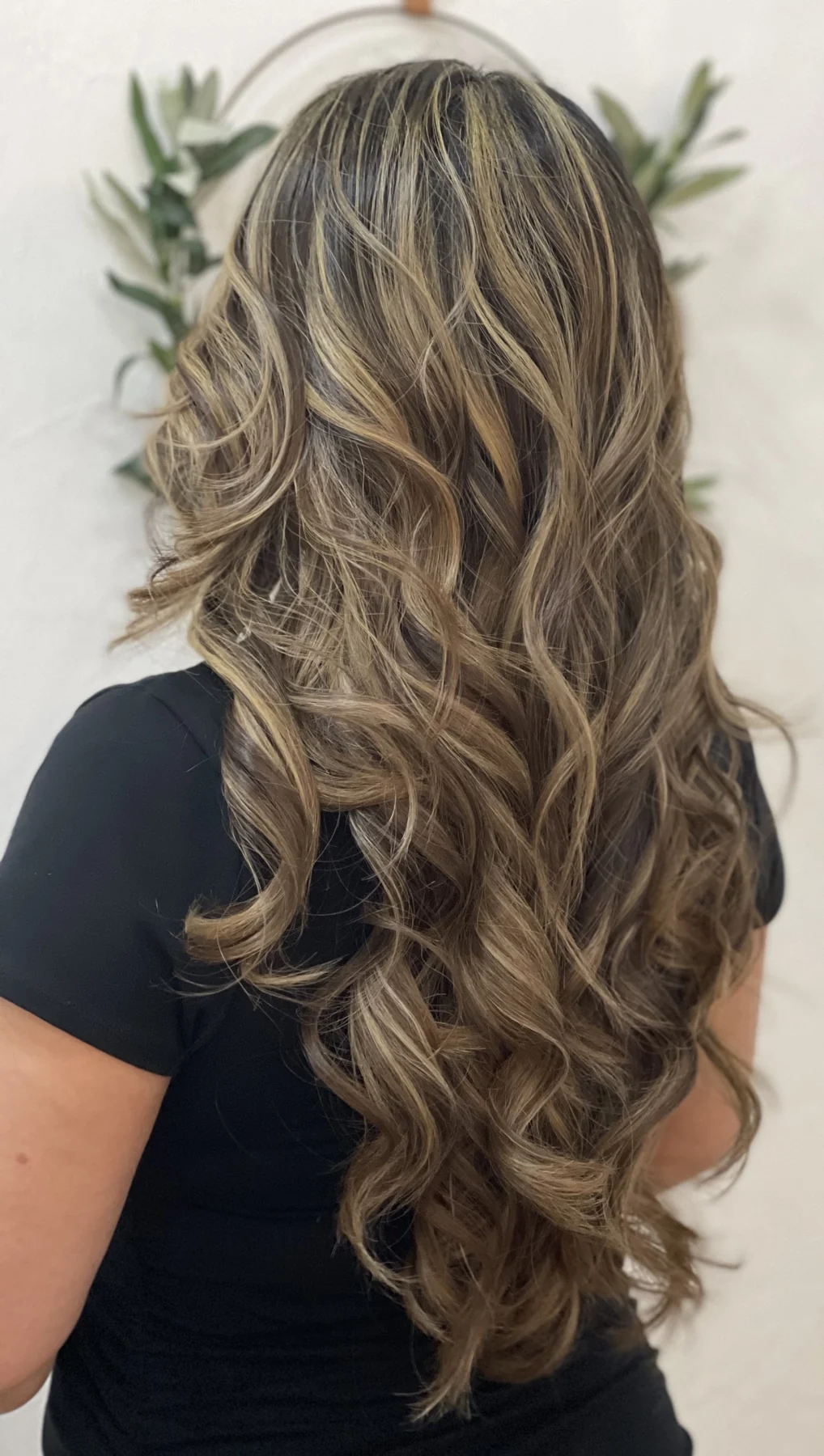 Back view of long brunette hair styled into polished waves